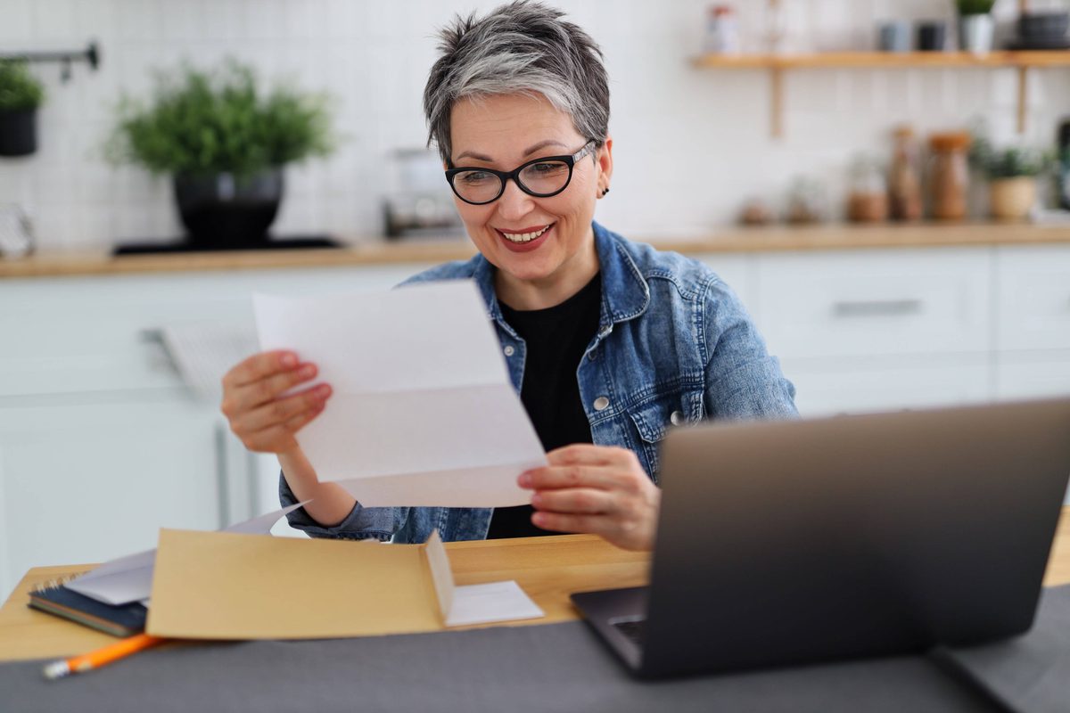Happy woman reviewing a bill showing that she saved money
