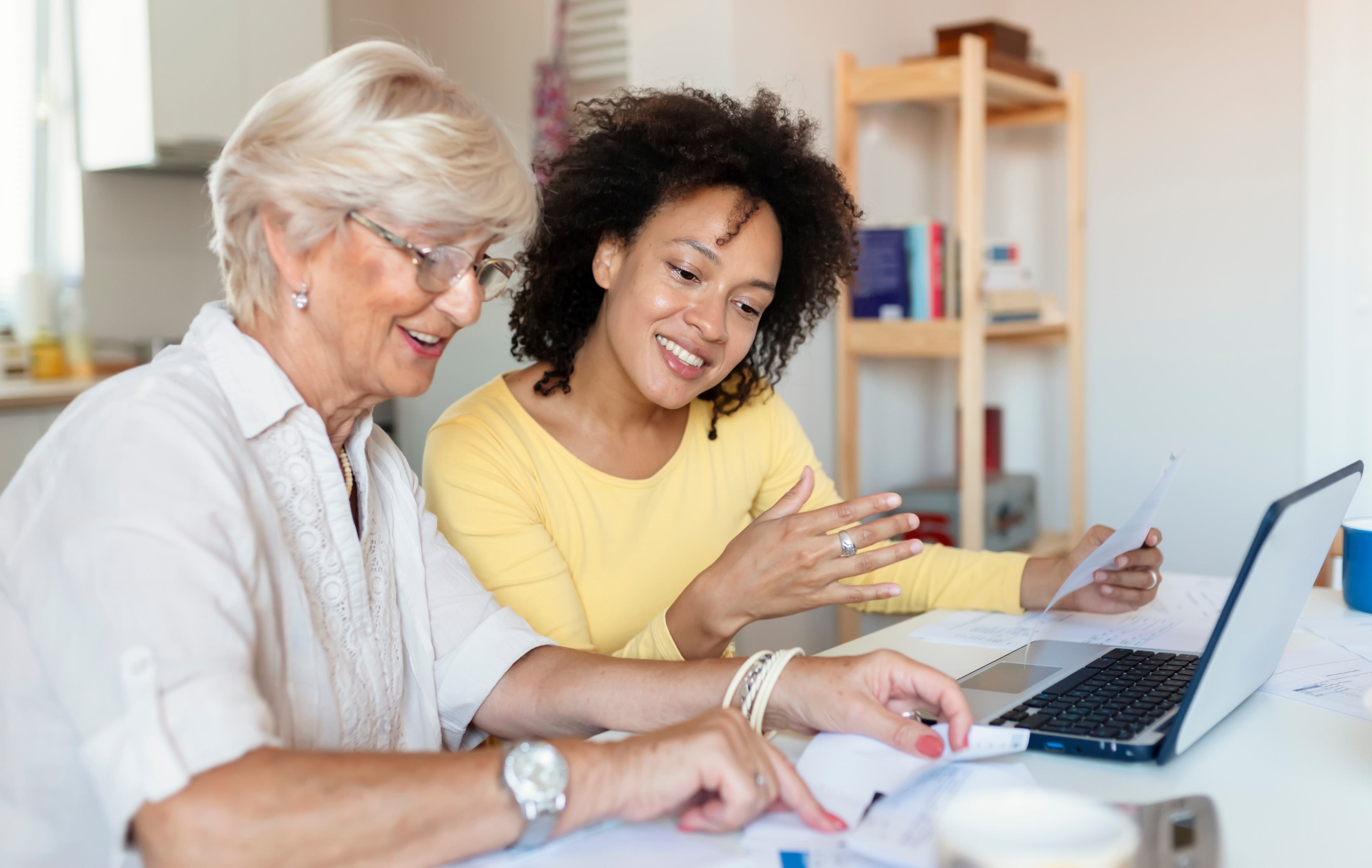 Two women reviewing a bill on a laptop