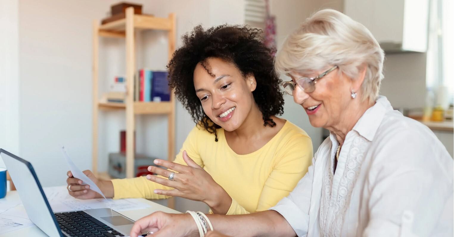 Woman helping elderly woman with documents